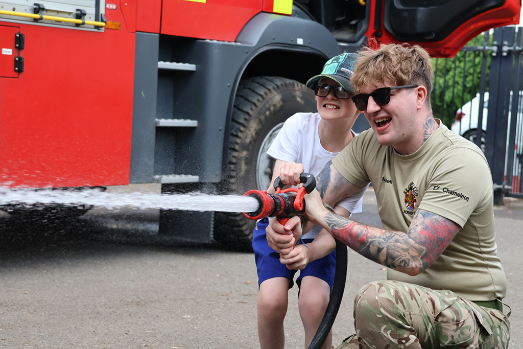 A student assists in the operation of a fire hose